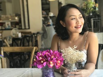 Portrait of smiling woman sitting on table