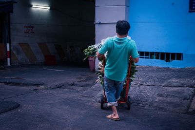 Rear view of boy standing against building