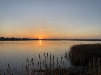 Scenic view of lake against sky during sunset