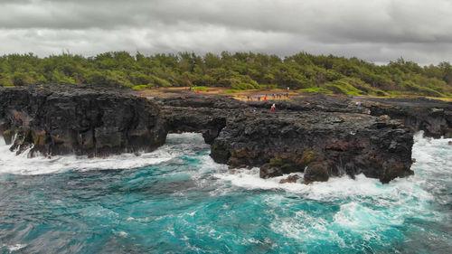 Scenic view of rocks in sea against sky