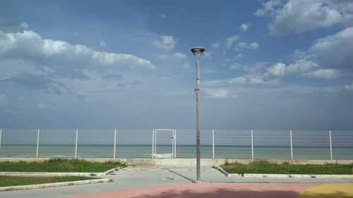 Street light by road against sky