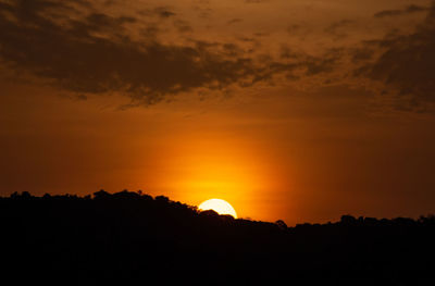 Scenic view of silhouette landscape against orange sky