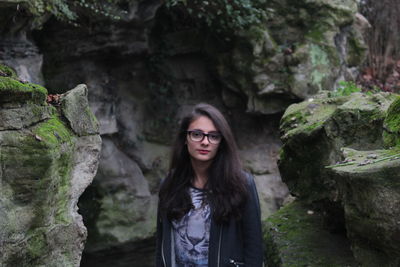 Portrait of young woman standing on rock