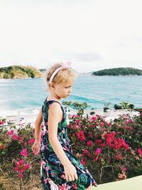 Full length of woman with arms raised against sea