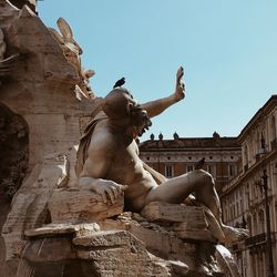 Birds perching on statue at fountain