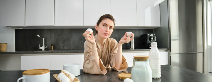 Portrait of young woman standing in kitchen