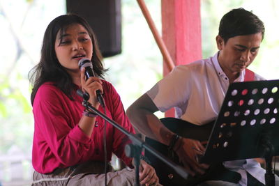 Side view of young woman singing