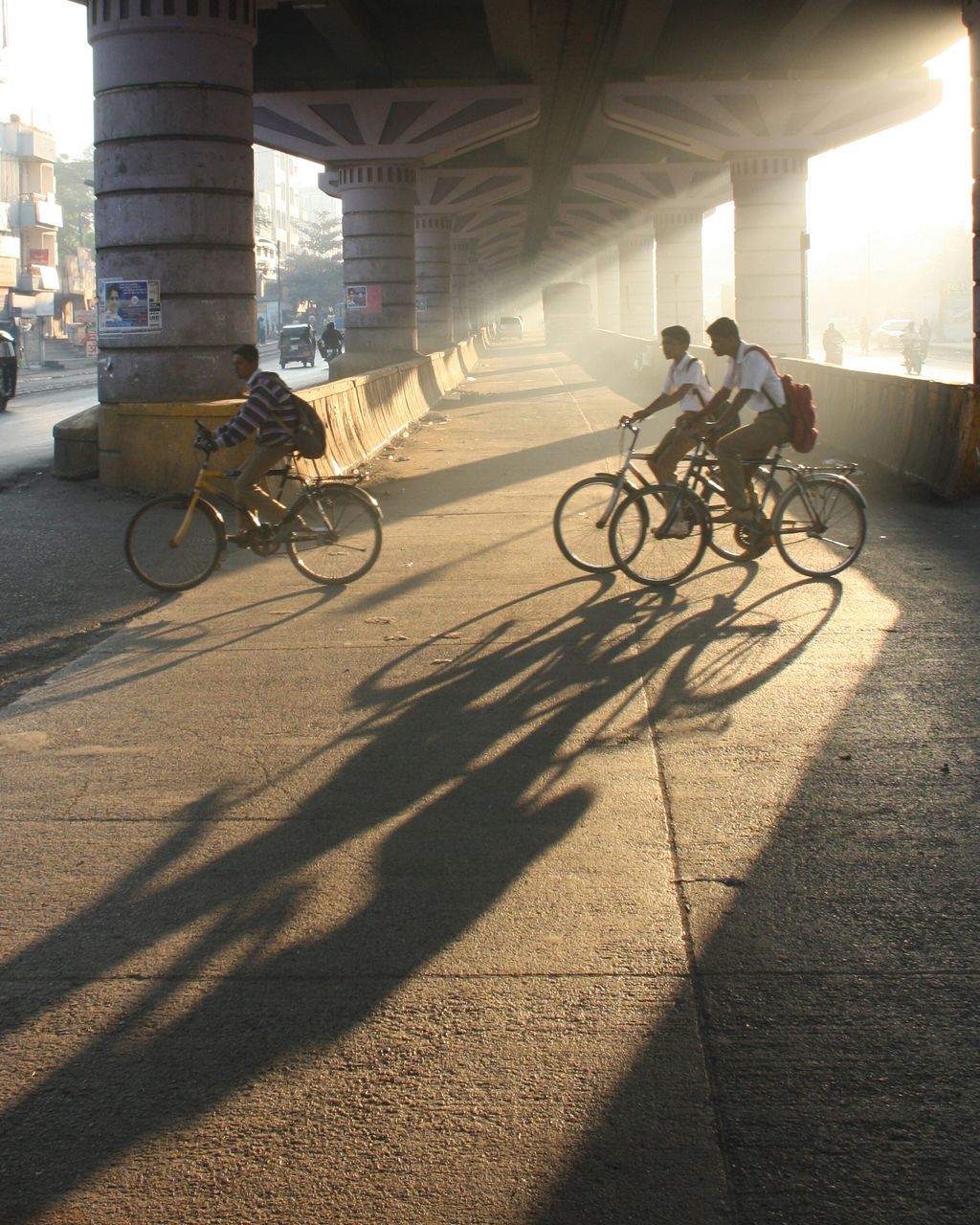 bicycle, land vehicle, transportation, mode of transport, riding, street, lifestyles, cycling, men, leisure activity, architecture, built structure, shadow, road, sunlight, car, stationary, full length