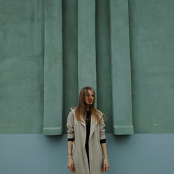 Portrait of young woman against wall