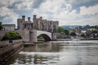 Arch bridge over river against buildings