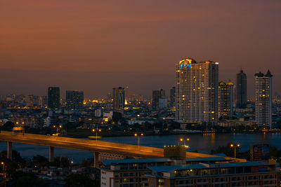 Illuminated buildings in city against sky at night