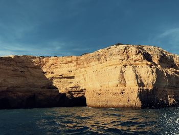 Rock formations by sea against sky