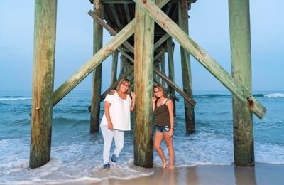 People standing on pier over sea