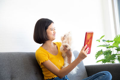 Young woman sitting on sofa at home