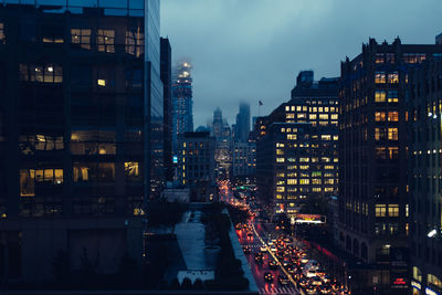 Illuminated buildings against sky at night