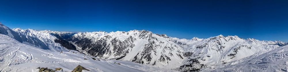 Scenic view of snowcapped mountains against clear blue sky