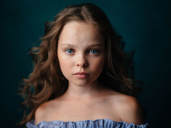 Portrait of cute teenage girl against black background