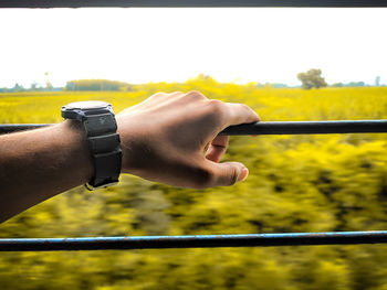 Close-up of hand holding window in train