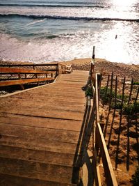 Wooden railing on beach by sea