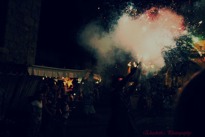 People enjoying firework display during event at night