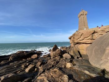 Rock formations on beach against sky