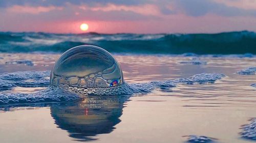 Close-up of sea against sky at sunset