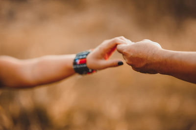 Cropped image of man and woman holding hand