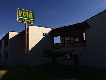 Low angle view of information sign against blue sky