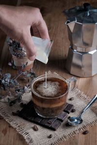 Cropped hand of person preparing coffee on table