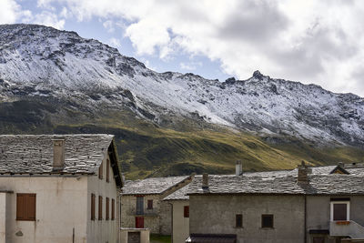 Houses against buildings and mountains against sky