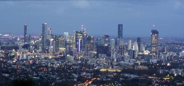 Aerial view of illuminated buildings in city against sky