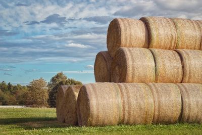 Hay bales on field against sky