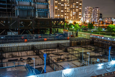 View of construction site with illuminated buildings in city at night