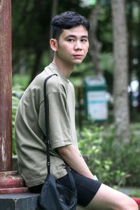 Portrait of young man standing in park