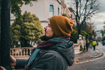 Side view of young man against trees