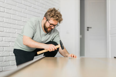 Side view of man using laptop while sitting on table