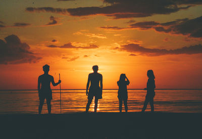 Silhouette people at beach during sunset