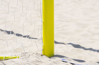 Close-up of yellow umbrella on beach