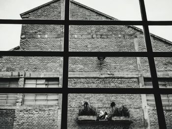 People sitting by window against building