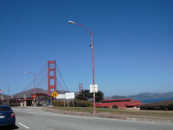 Street by road against clear blue sky