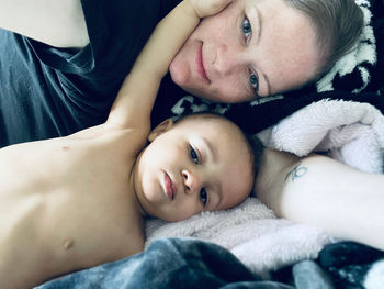 Portrait of young woman lying on bed at home