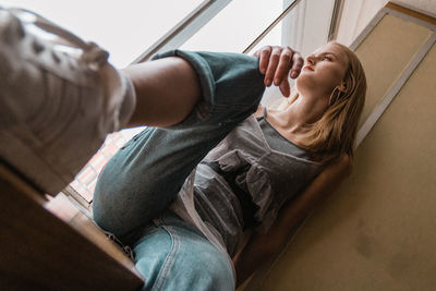 Midsection of young woman sitting at home