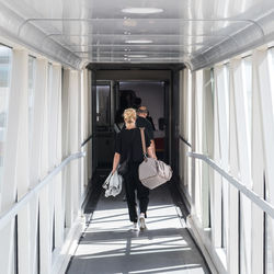 Full length of woman walking on escalator