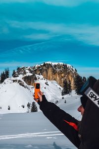 Person on snow covered landscape against sky