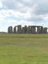 Built structure on field against cloudy sky