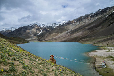 Scenic view of lake by mountains against sky