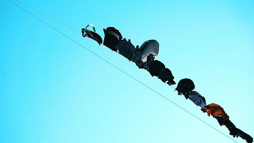 Low angle view of clothes drying on rope against clear sky