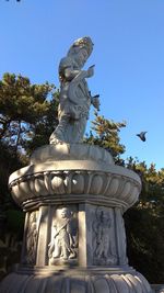 Low angle view of statue against sky in park