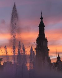 Silhouette of building against cloudy sky during sunset