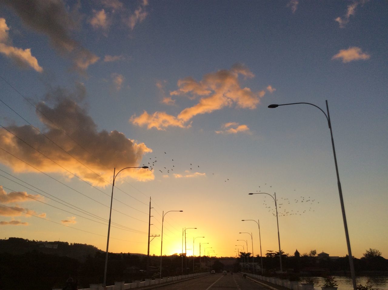 sunset, sky, street light, road, electricity pylon, orange color, the way forward, silhouette, transportation, power line, cloud - sky, electricity, connection, beauty in nature, scenics, nature, diminishing perspective, tranquility, street, cloud